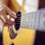 Person playing an acoustic guitar