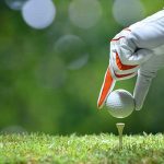 Golf player teeing up